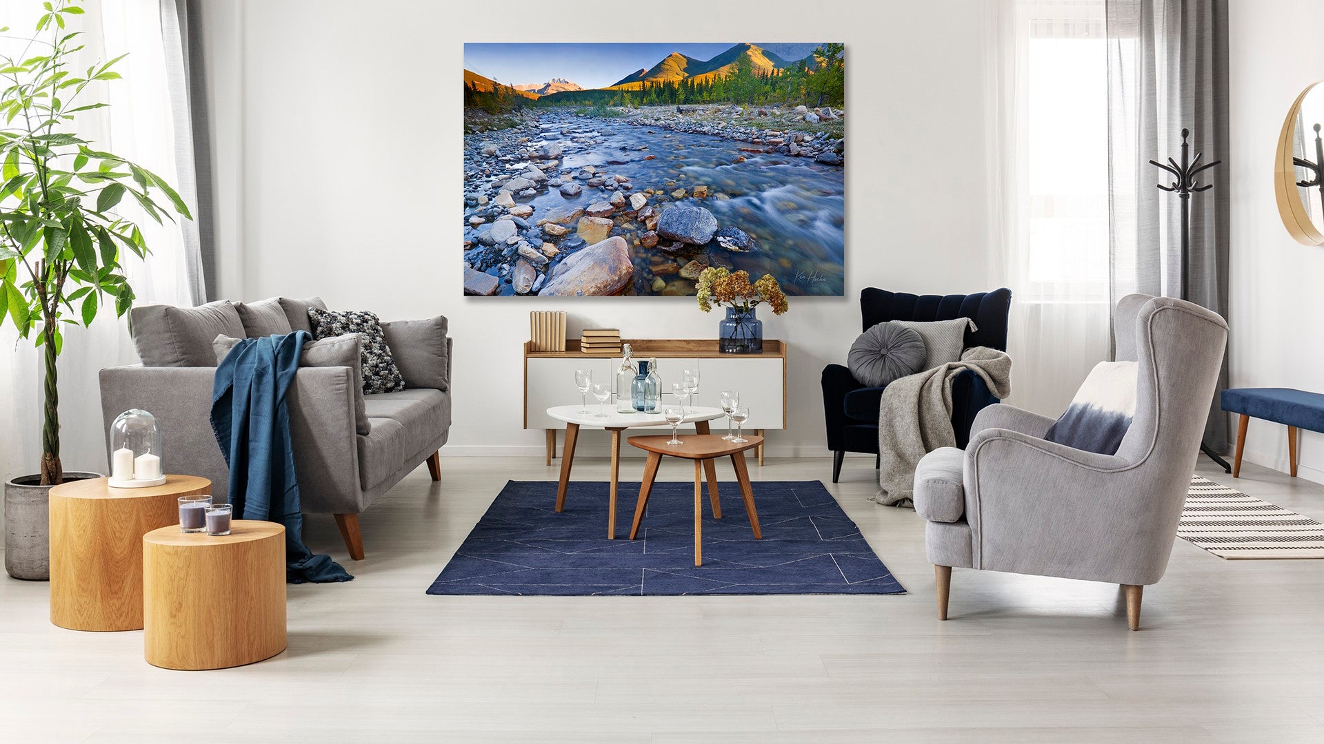 Cozy living room decor imagery with couch, sidetable, coffee table, large photographic wall hanging of Evan Thomas Creek